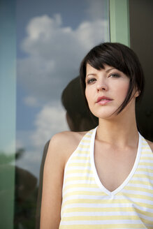 Portrait of young woman in front of a window - TOYF001132