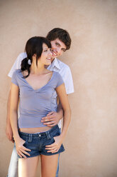 Portrait of young couple leaning against wall - TOYF001140