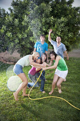 Five friends splashing with water in the garden - TOYF001150