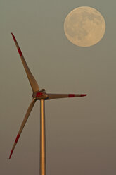 Deutschland, Vollmond in der Abenddämmerung mit Windrad im Vordergrund - UMF000788