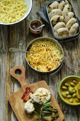 Spaghetti mit Tomatenpesto, Parmesan und selbstgemachten Brötchen mit Oliven und Tomaten auf einem Holzbrett - ODF001206