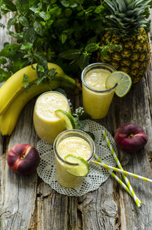 Smoothies aus Bananen, Ananas und Minze auf einem Holztisch - ODF001218