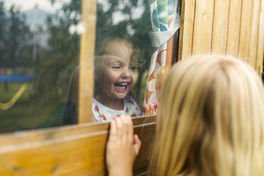 Spanien, Asturien, Gijon, Kleine Mädchen spielen durch ein Glasfenster - MGOF000473