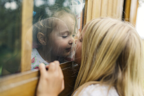 Spanien, Asturien, Gijon, Kleine Mädchen spielen durch ein Glasfenster - MGOF000474