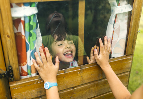 Spanien, Asturien, Gijon, Kleine Mädchen spielen durch ein Glasfenster - MGOF000476