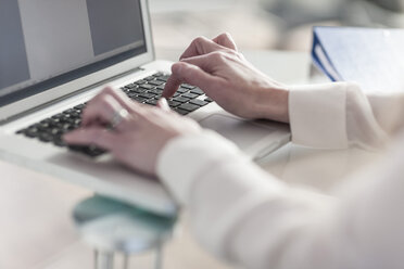 Close-up of person at desk working at laptop - ZEF007428