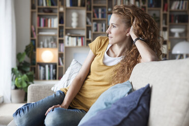 Frau zu Hause auf der Couch sitzend - RBF003071