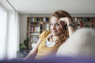 Smiling woman at home sitting on couch - RBF003072