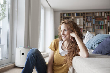 Smiling woman at home sitting on floor - RBF003104