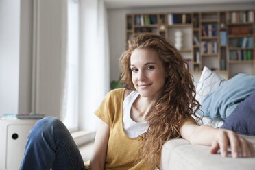 Smiling woman at home sitting on floor - RBF003106