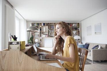 Woman at home using laptop on secretary desk - RBF003110