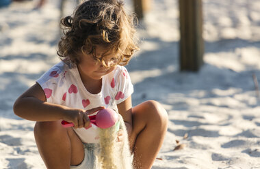 Little girl playing in sandbox on playground - MGOF000477