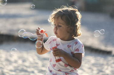 Little girl making soap bubbles at playground - MGOF000480