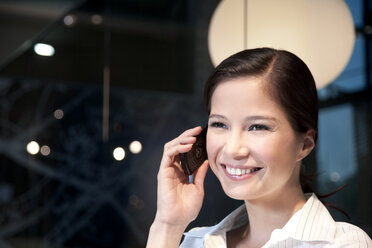 Smiling young businesswoman on the phone - TOYF001251