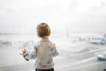 Spain, Barcelona, back view of little boy looking through window at the airport - JRFF000002