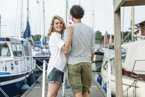 Germany, Luebeck, smiling couple at marina stock photo