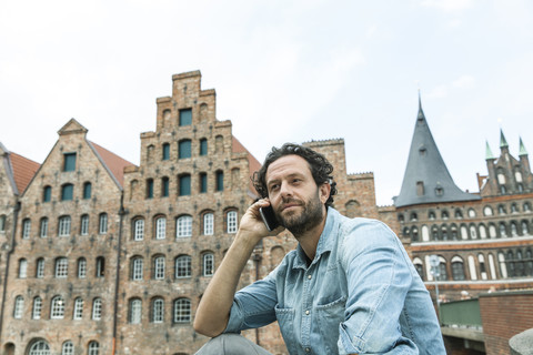 Deutschland, Lübeck, Mann am Handy in der Stadt, lizenzfreies Stockfoto