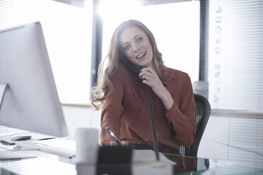 Young woman on the phone at desk - ZEF007138