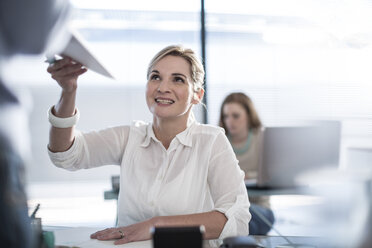 Woman in office handing over papers - ZEF007191