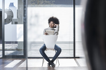 Woman sitting on a chair in office thinking - ZEF007194