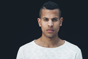 Portrait of young man in front of black background - CHAF001395