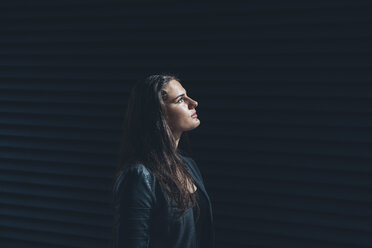 Black dressed young woman in front of black facade - CHAF001391