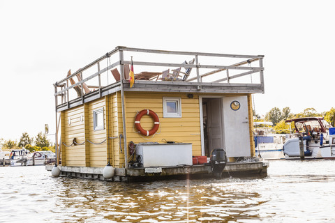 Beine eines Paares auf der Dachterrasse auf einem Hausboot, lizenzfreies Stockfoto