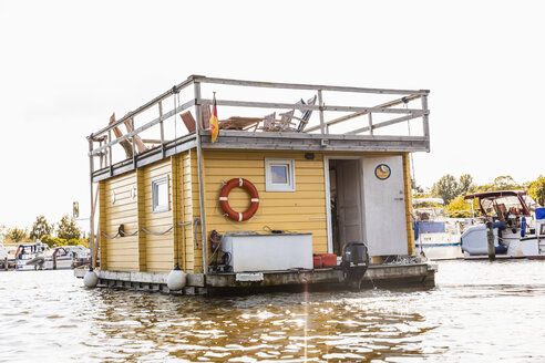 Legs of a couple on roof terrace on a house boat - FMKF001933