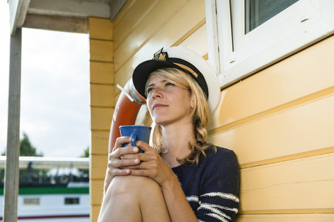 Releaxed woman on a house boat with coffee cup stock photo