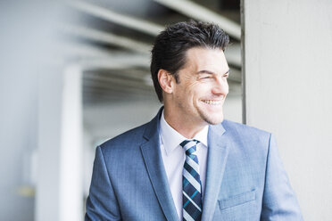 Portrait of smiling businessman looking at distance - UUF005345