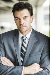 Portrait of serious looking businessman wearing grey suit - UUF005347