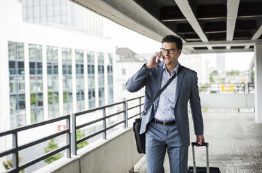 Businessman on business trip telephoning with smartphone - UUF005355