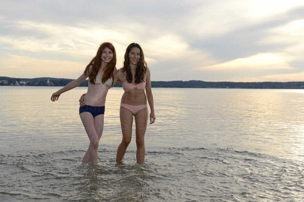 Two young women wading into the sea for a swim in their underwear