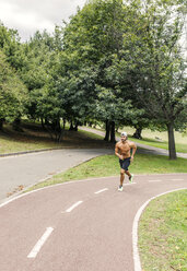 Sportlicher junger Mann beim Joggen im Park - MGOF000491