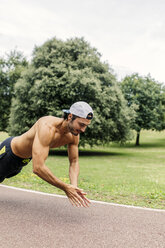 Sportlicher junger Mann beim Workout im Park - MGOF000493