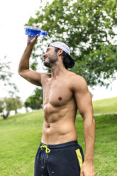 Athletic young man refreshing after training in the park - MGOF000555