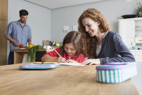 Little girl doing homework at the kitchen table stock photo