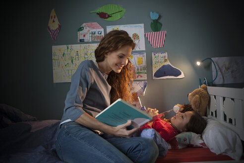 Mutter liest ihrer kleinen Tochter eine Gute-Nacht-Geschichte vor - RBF003380
