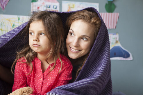 Porträt einer lächelnden Mutter und ihrer unglücklichen kleinen Tochter im Kinderzimmer - RBF003384