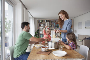 Ehepaar mit zwei Kindern, das gemeinsam zu Hause zu Mittag isst - RBF003407