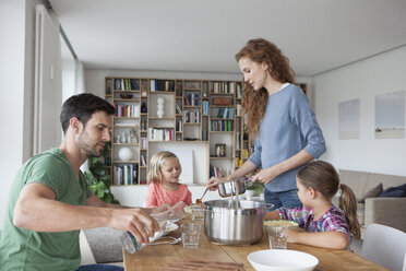 Ehepaar mit zwei Kindern, das gemeinsam zu Hause zu Mittag isst - RBF003408