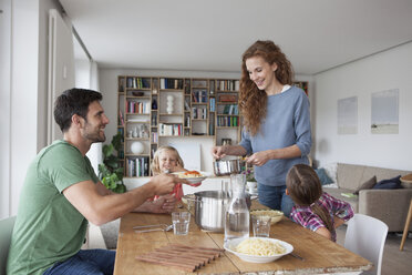 Ehepaar mit zwei Kindern, das gemeinsam zu Hause zu Mittag isst - RBF003409