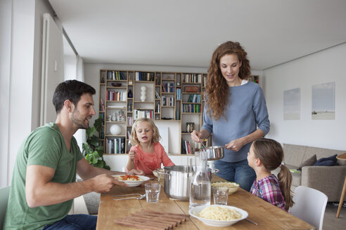 Ehepaar mit zwei Kindern, das gemeinsam zu Hause zu Mittag isst - RBF003410