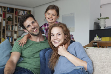 Portrait of happy couple and little daughter on the couch at home - RBF003423