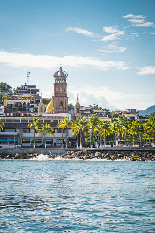 Mexiko, Jalisco, Puerto Vallarta vom Meer aus gesehen, mit Turm der Kirche Our Lady of Guadalupe, lizenzfreies Stockfoto