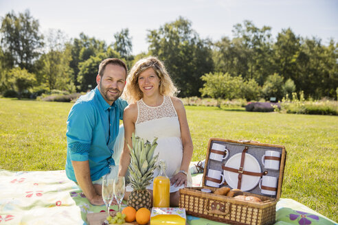 Glückliches Paar beim Picknick im Park, schwangere Frau - ROMF000151