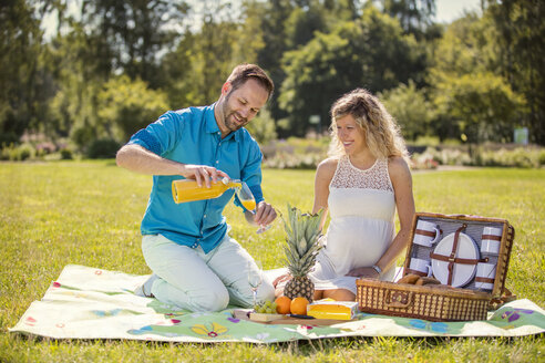 Glückliches Paar beim Picknick im Park, schwangere Frau - ROMF000152