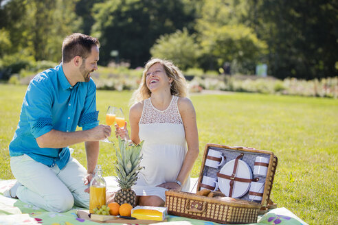 Glückliches Paar beim Picknick im Park, schwangere Frau - ROMF000153