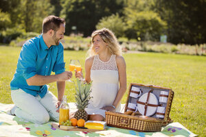 Glückliches Paar beim Picknick im Park, schwangere Frau - ROMF000154