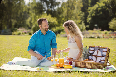 Glückliches Paar beim Picknick im Park, schwangere Frau - ROMF000155